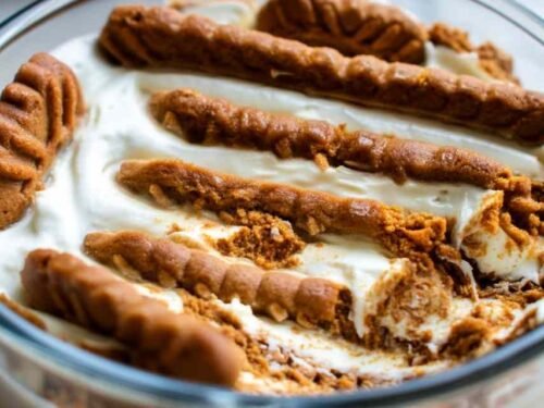 2-ingredient yogurt cheesecake unmolded on a plate topped with fresh berries and honey drizzle