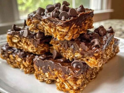 Stack of homemade 5-Ingredient No-Bake Protein Bars with dark chocolate topping resting on parchment paper