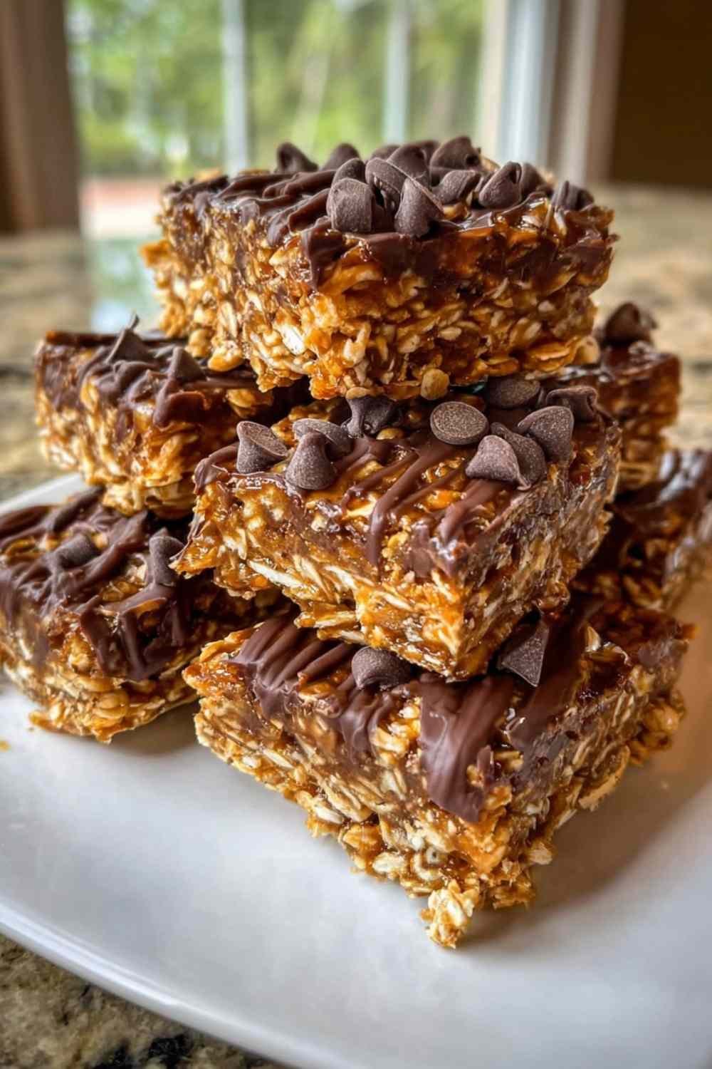 Stack of homemade 5-Ingredient No-Bake Protein Bars with dark chocolate topping resting on parchment paper