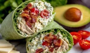 California Club Wraps California club wraps sliced in half on a plate showing layers of chicken, avocado, bacon, and Monterey Jack cheese