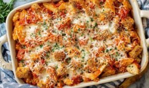 Chicken Parmesan Casserole Chicken Parmesan casserole in a white baking dish with melted mozzarella, crispy chicken, and fresh parsley garnish