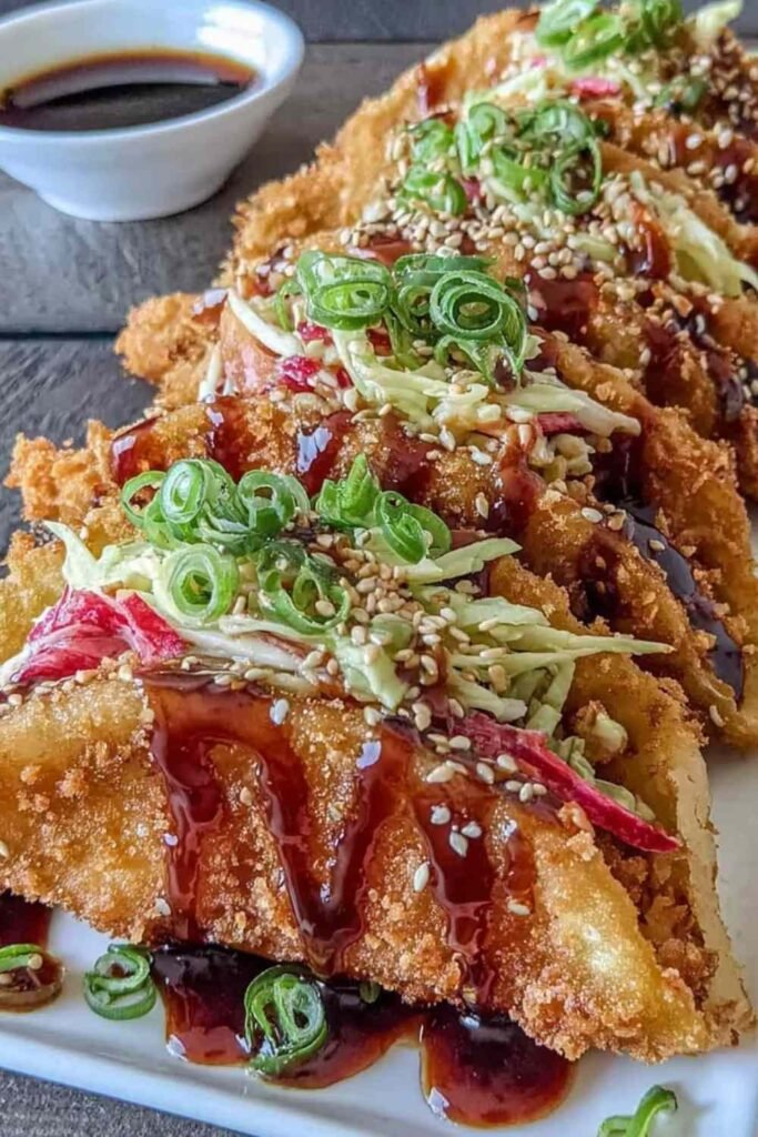 Crispy chicken wonton tacos with teriyaki glaze on white plate showing golden wonton shells with chicken and toppings