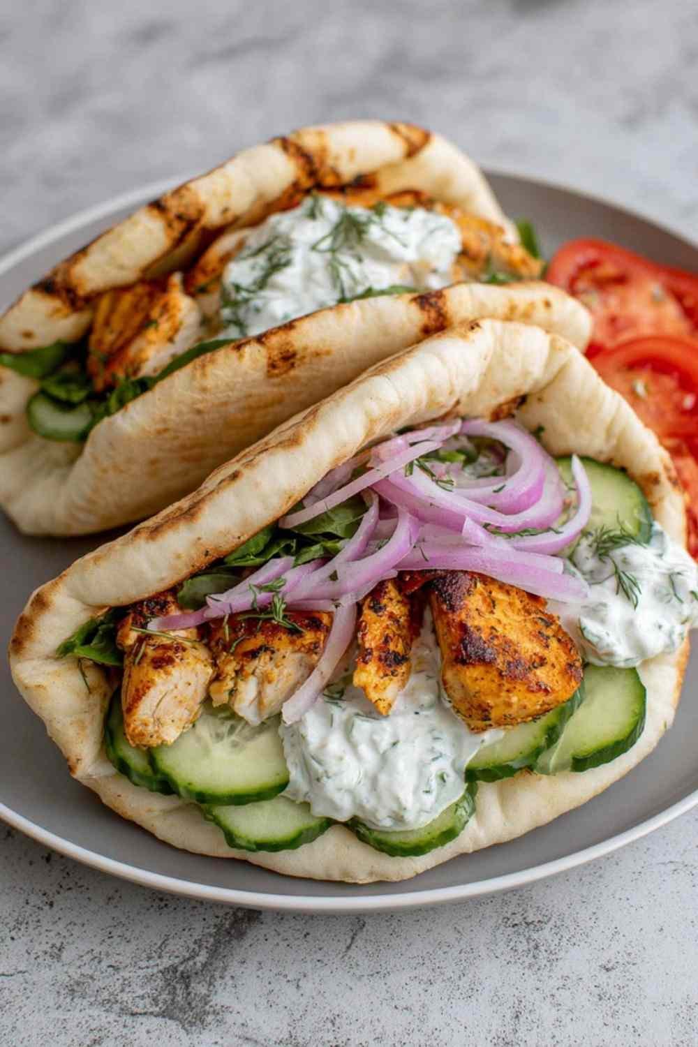 Crockpot Greek Chicken Pitas with Tzatziki filled with shredded chicken, cucumbers, tomatoes, and feta cheese