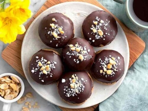 High Protein Frozen Peanut Butter Greek Yogurt Bites coated in dark chocolate with flaky sea salt on parchment paper