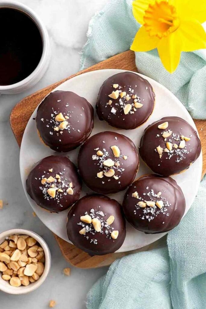 High Protein Frozen Peanut Butter Greek Yogurt Bites coated in dark chocolate with flaky sea salt on parchment paper