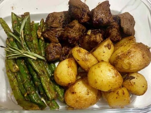 Garlic Balsamic Steak Bites in a meal prep bowl with roasted baby gold potatoes and blistered green beans