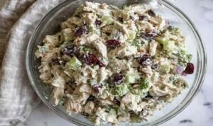 Healthy chicken salad no mayo in bowl with Greek yogurt, grapes, walnuts and fresh herbs