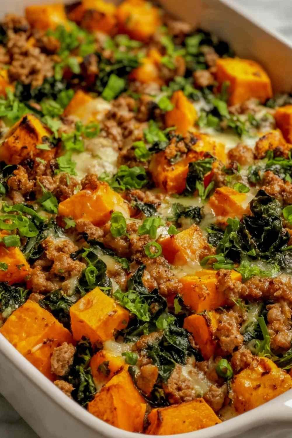 Ground turkey sweet potato bake with melted cheddar and roasted vegetables in a baking dish
