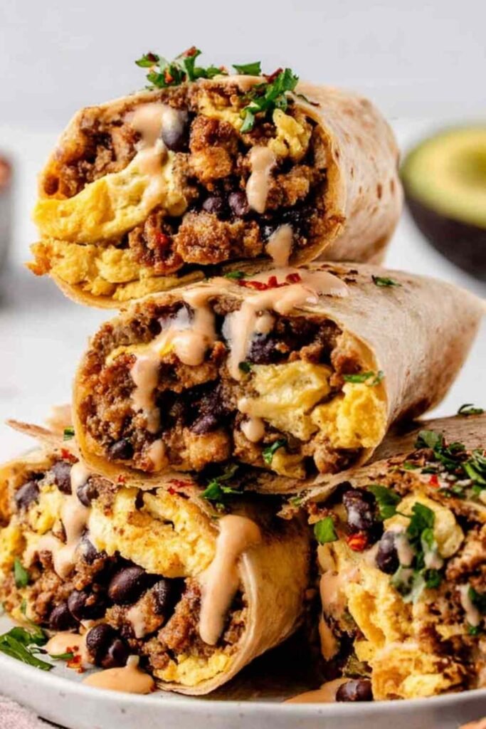 High protein breakfast burrito wrapped in aluminum foil on a baking sheet ready for the freezer