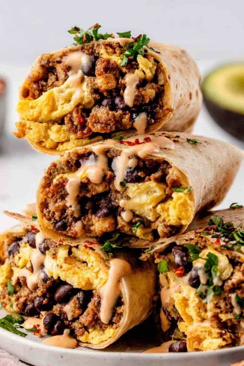 High protein breakfast burrito wrapped in aluminum foil on a baking sheet ready for the freezer