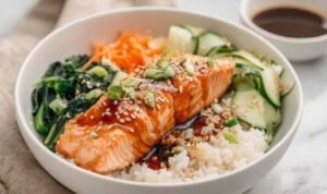 High Protein Low Calorie Teriyaki Salmon Bowls High protein low calorie teriyaki salmon bowl with glazed salmon broccoli edamame cucumber carrots and sesame seeds over rice