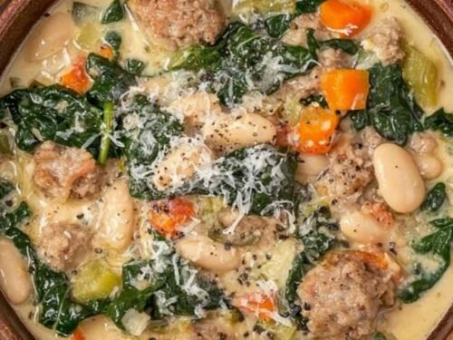 Italian sausage and white bean soup in a Dutch oven with kale, potatoes, and creamy broth