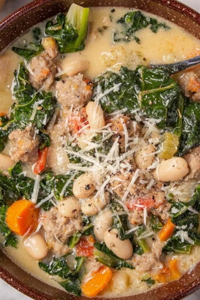 Italian sausage and white bean soup in a Dutch oven with kale, potatoes, and creamy broth