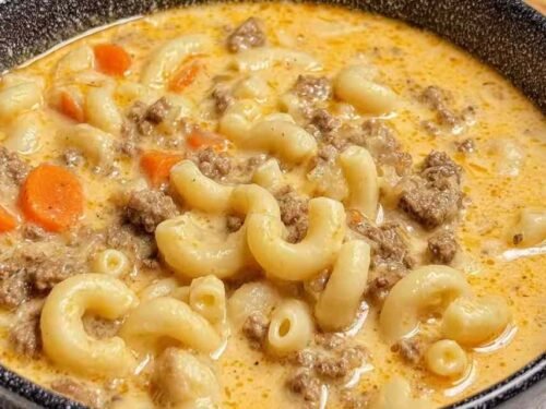 A pot of macaroni cheeseburger soup with ground beef, elbow pasta, and melted cheddar in a thick cheesy broth