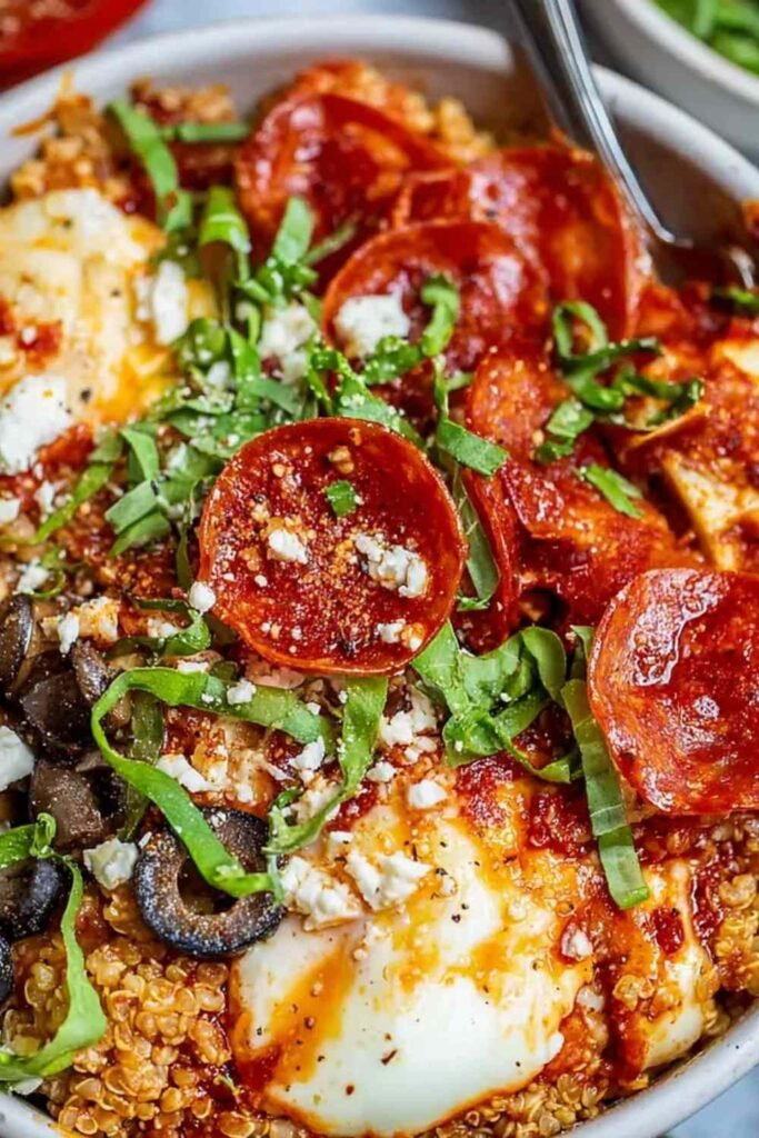 Pizza protein bowl with melted mozzarella, pepperoni, and fresh basil in an oven-safe bowl