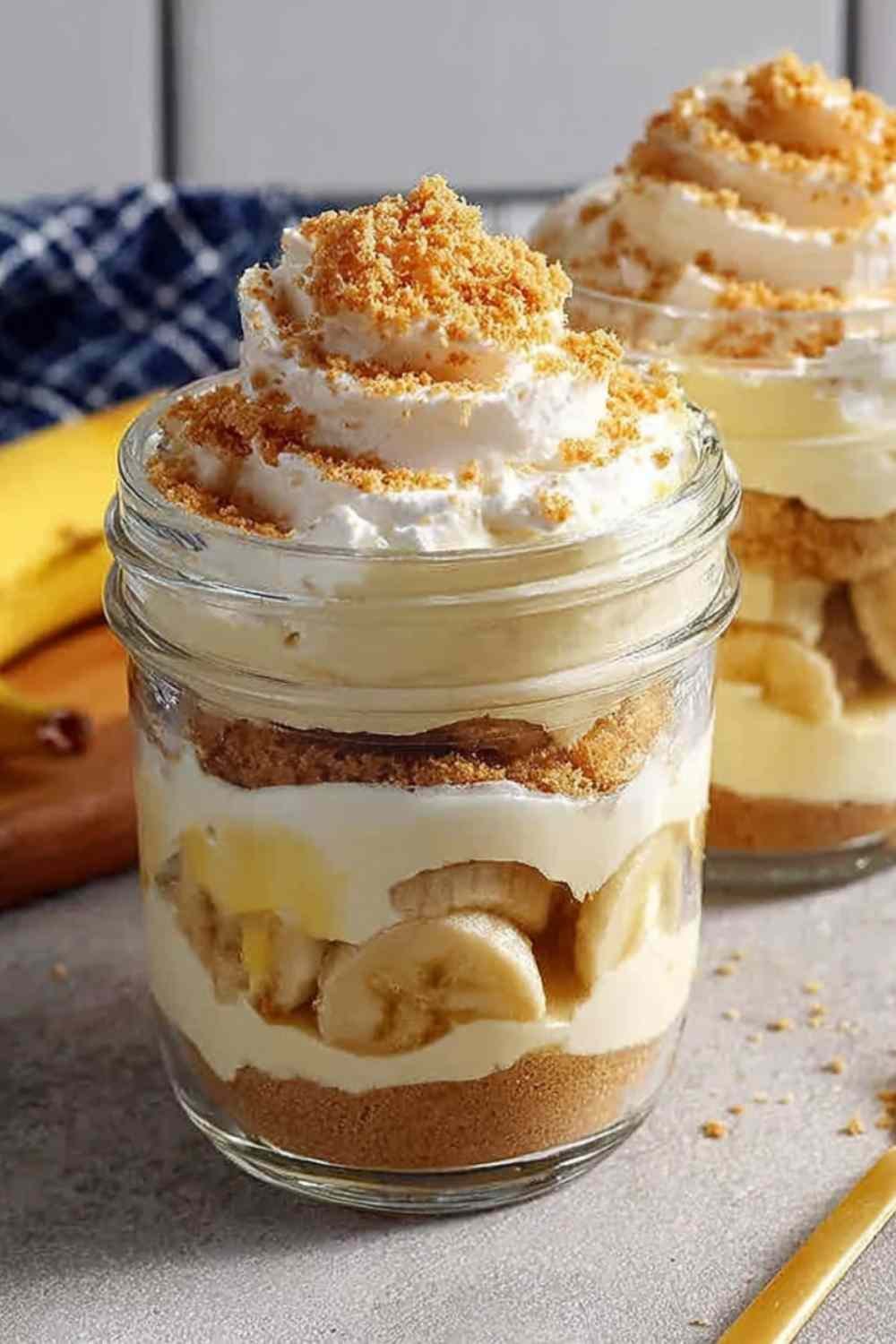 Protein banana pudding layered in glass jars with vanilla custard, crushed wafers, and fresh banana slices