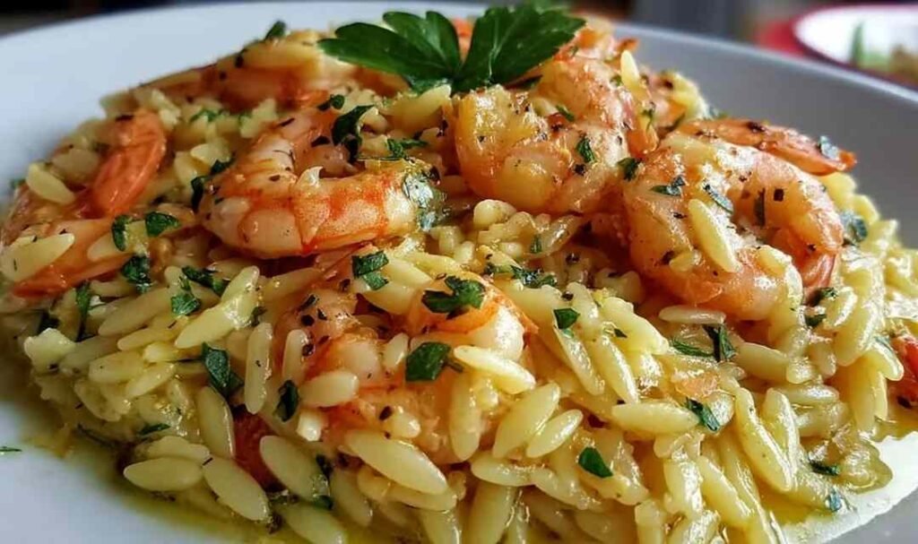 Shrimp orzo lemon garlic sauce in a skillet with pink seared shrimp, tender orzo, and fresh parsley