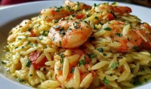Shrimp orzo lemon garlic sauce in a skillet with pink seared shrimp, tender orzo, and fresh parsley