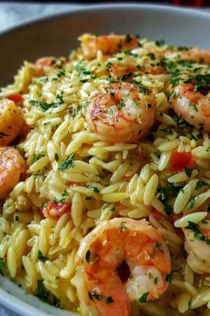 Shrimp orzo lemon garlic sauce in a skillet with pink seared shrimp, tender orzo, and fresh parsley