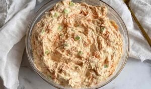 Buffalo tuna salad in a glass bowl with cottage cheese, celery, red onion, and Buffalo sauce ready to serve