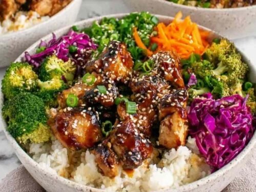 Sticky chicken bowls with glazed chicken thighs over jasmine rice and steamed broccoli garnished with sesame seeds and green onions
