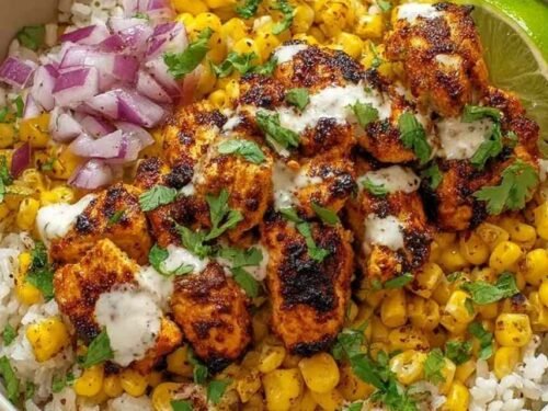 Street corn chicken rice bowl with charred corn, juicy chicken breast, diced avocado, Cotija cheese, and fresh cilantro over brown rice