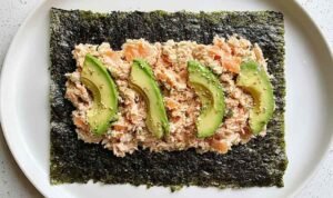 Tuna Salad Nori Wraps (Paleo) Tuna salad nori wraps with avocado slices and sesame seeds on a white plate