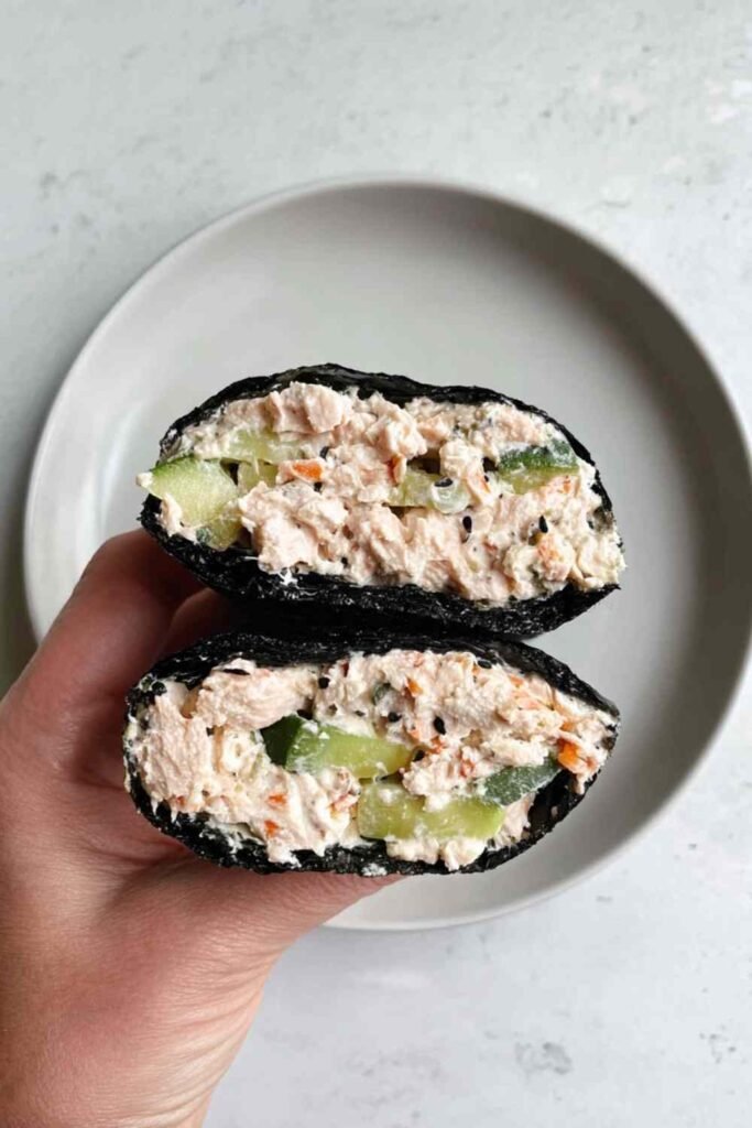 Tuna salad nori wraps with avocado slices and sesame seeds on a white plate