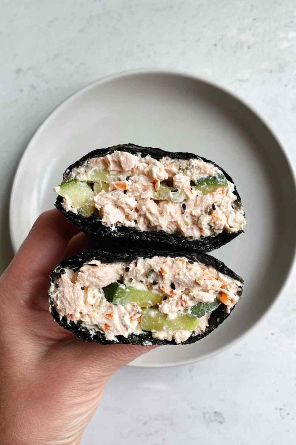 Tuna salad nori wraps with avocado slices and sesame seeds on a white plate
