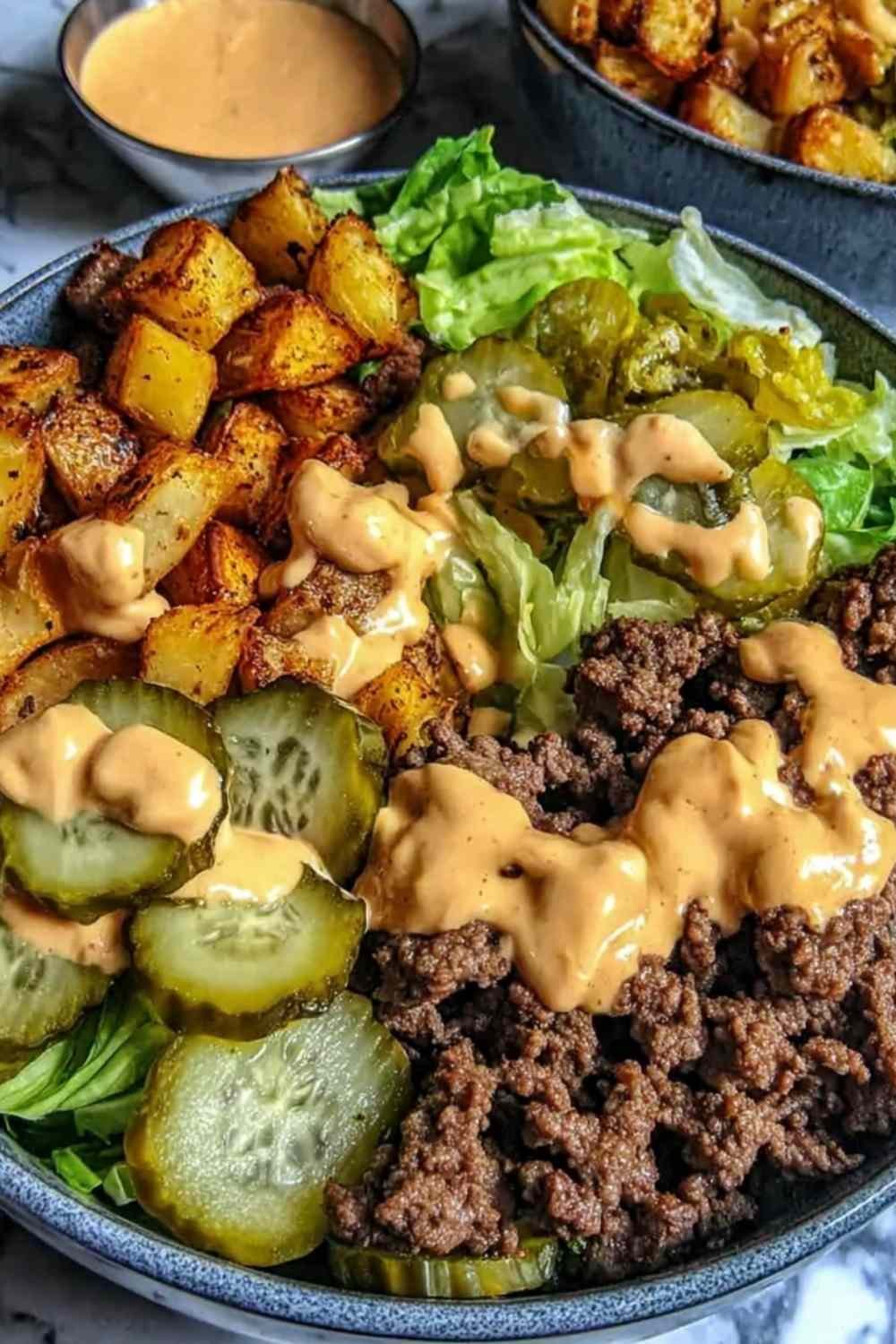 Burger bowls with crispy potato wedges, seasoned ground beef, shredded lettuce, cheese, and homemade burger sauce
