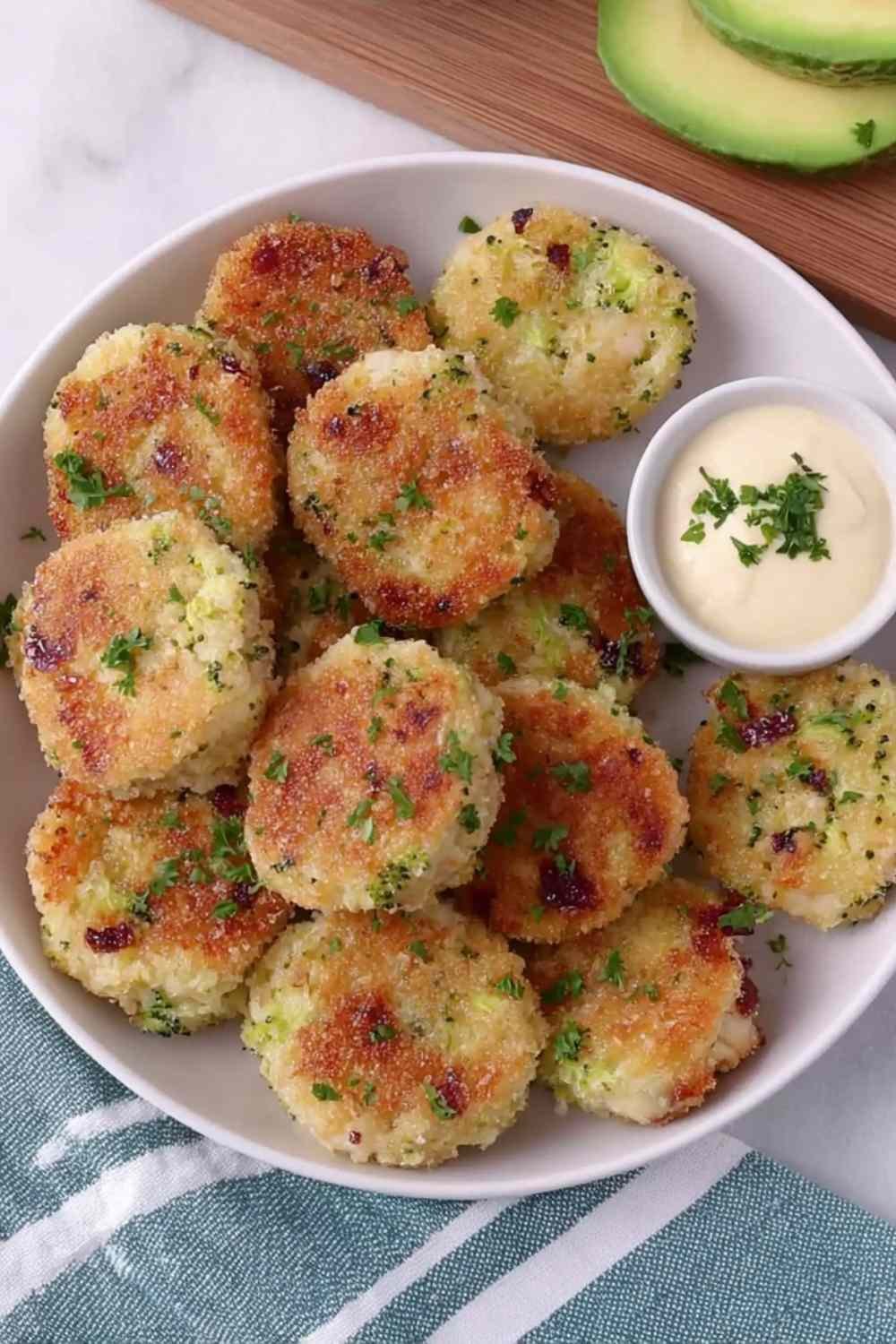 Homemade chicken and broccoli nuggets for baby arranged on a white plate, golden and ready to serve