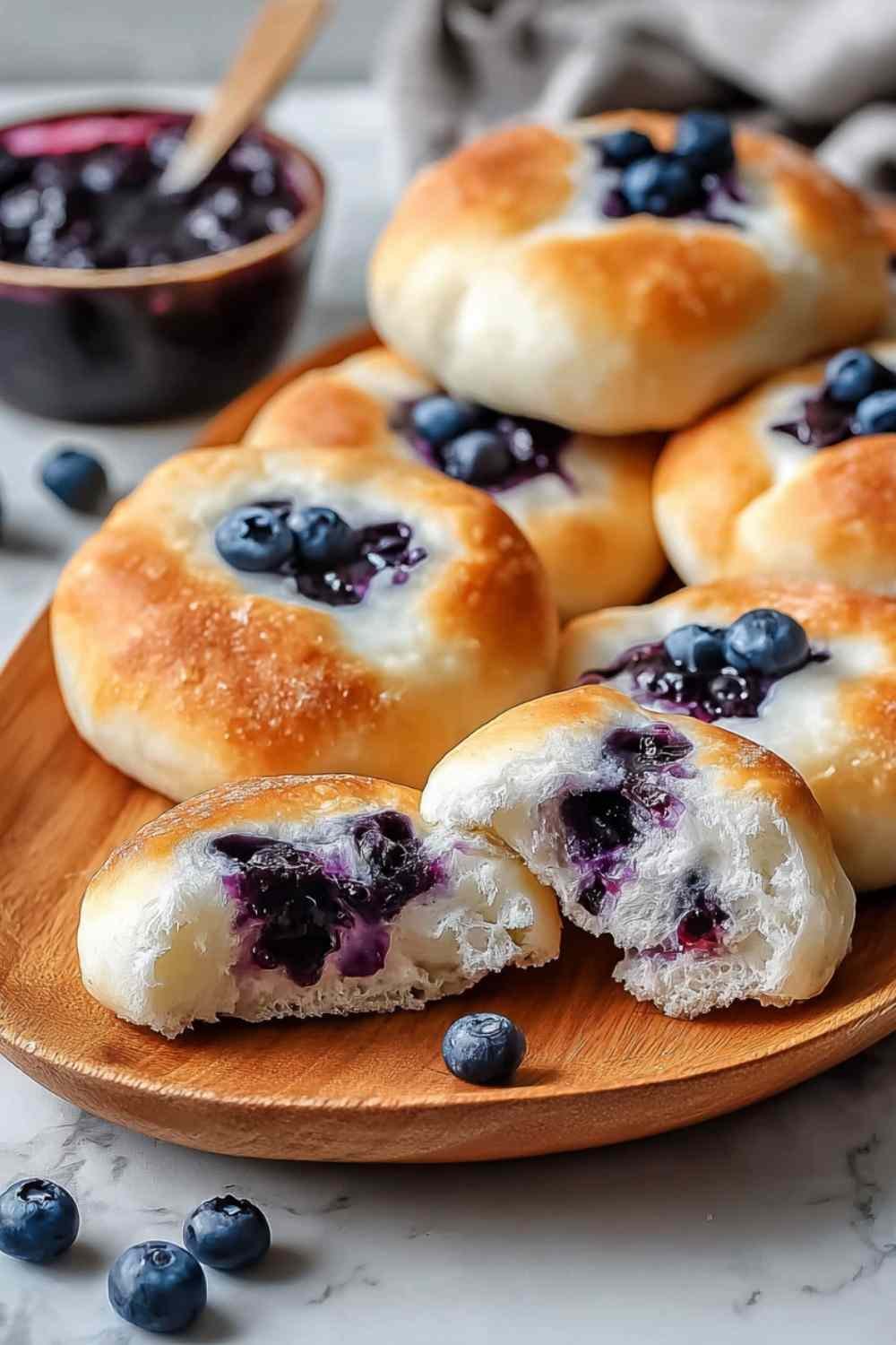 Golden Cottage Cheese Blueberry Cloud Bread rounds on a parchment-lined baking sheet fresh from the oven puffed and firm