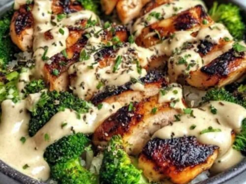 Grilled chicken and broccoli bowl with creamy garlic sauce served over brown rice in a white bowl
