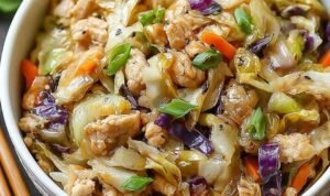 Egg Roll Bowls with Chicken and Cabbage Egg roll bowls with chicken and cabbage topped with sesame seeds and green onions in a white bowl