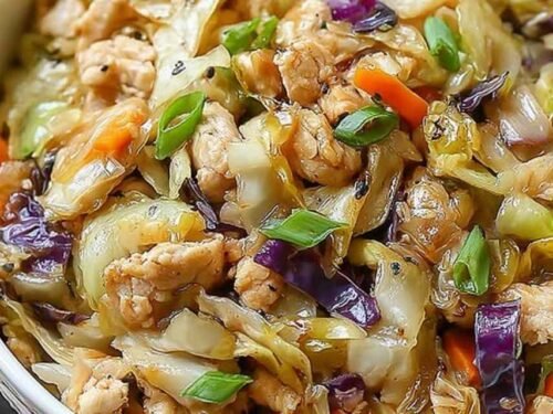 Egg roll bowls with chicken and cabbage topped with sesame seeds and green onions in a white bowl
