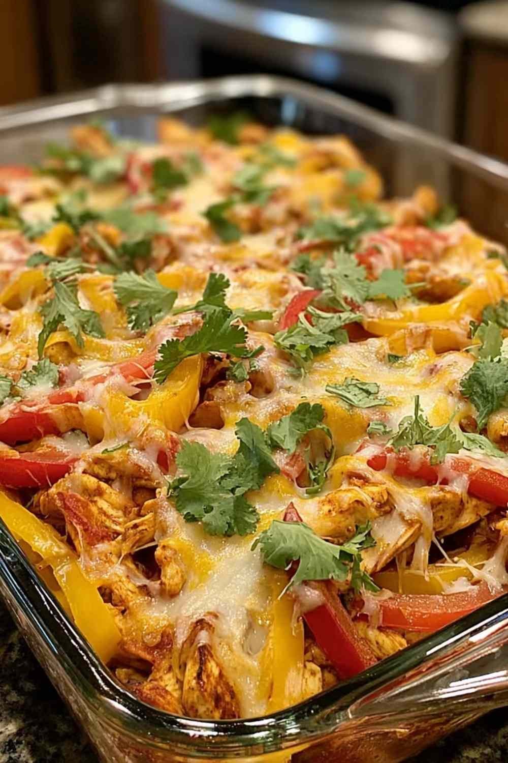 Fajita chicken casserole bake in a 9x13 dish with melted Mexican cheese blend bubbling on top fresh from the oven
