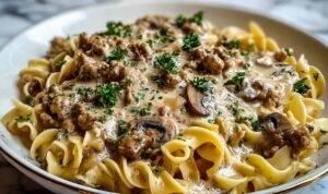 Creamy ground turkey stroganoff served over egg noodles garnished with fresh parsley in a white bowl
