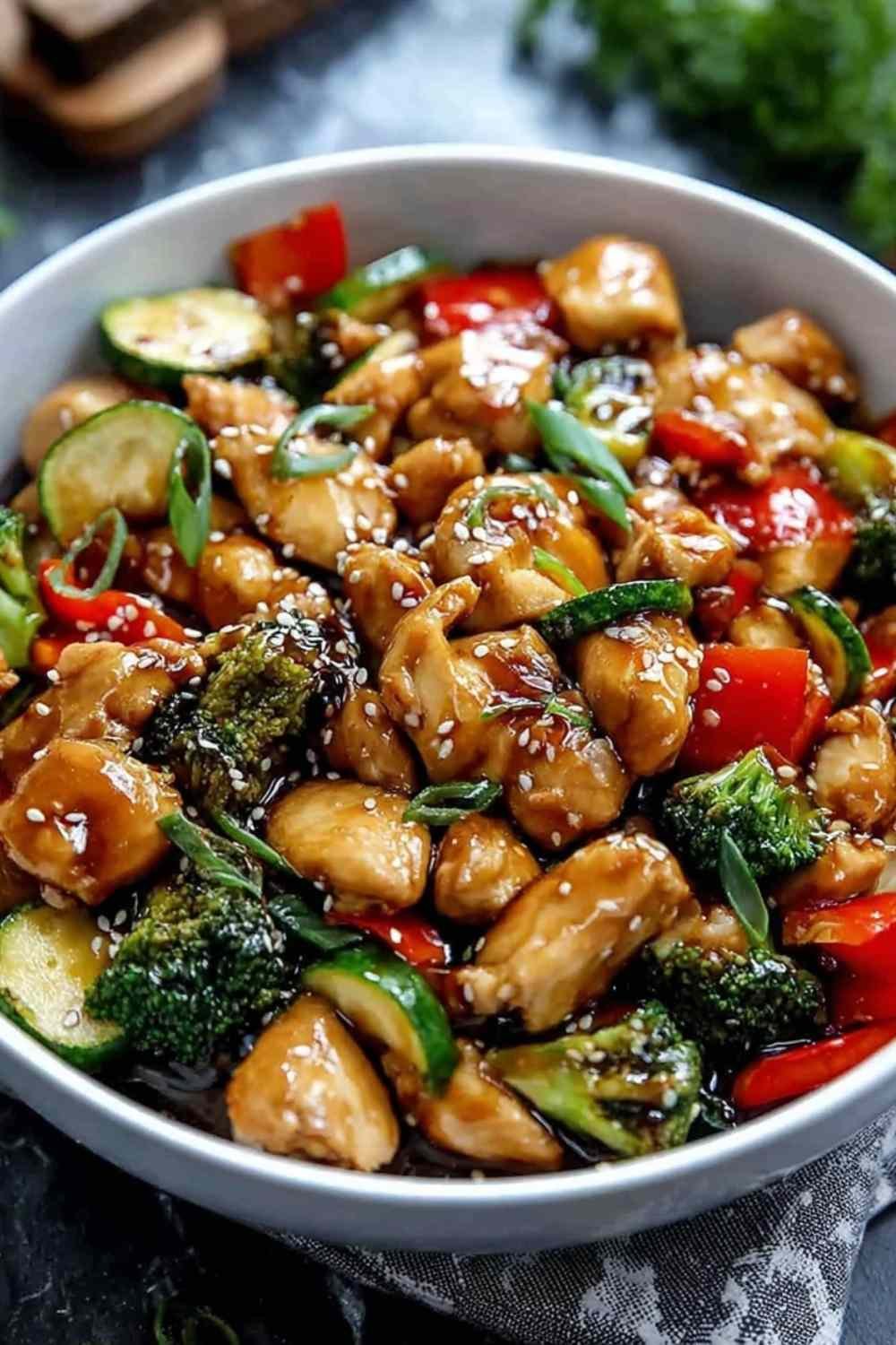 Honey Garlic Chicken Stir Fry with golden chicken pieces and colorful vegetables cooking in a large skillet with glossy sauce