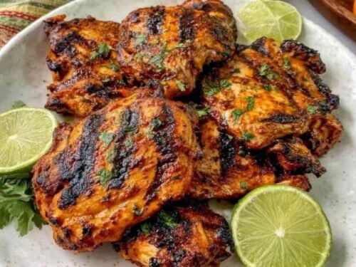Pollo asado Chipotle copycat chicken thighs on a grill with dark char marks and smoky chipotle marinade glaze