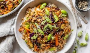 Turkey Egg Roll In A Bowl Turkey egg roll in a bowl cooking in a large skillet with coleslaw, carrots, edamame, and soy-sesame sauce