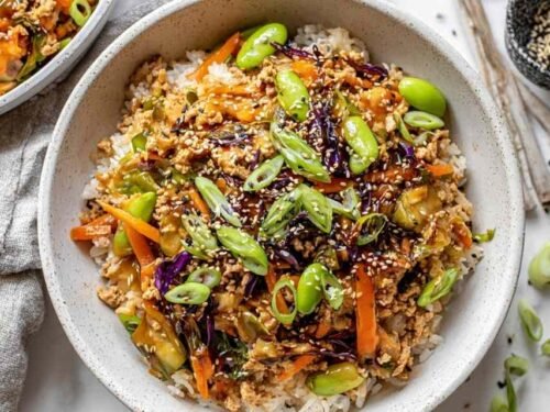 Turkey egg roll in a bowl cooking in a large skillet with coleslaw, carrots, edamame, and soy-sesame sauce