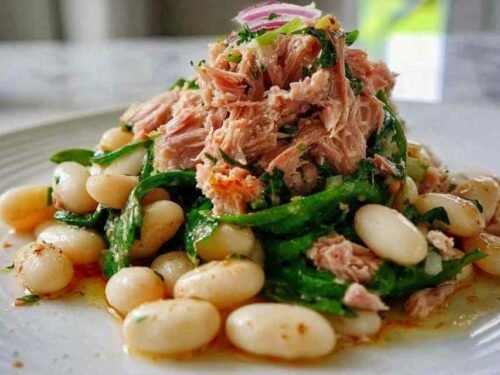 Tuna and white bean salad with lemon vinaigrette served in a large bowl with fresh parsley and red onion